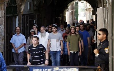 Les forces de sécurité israéliennes montent la garde alors qu'un groupe d'hommes juifs achève sa visite du mont du Temple à Jérusalem, à Tisha BeAv, le 14 août 2016. (Crédit : AFP/Ahmad Gharabli)