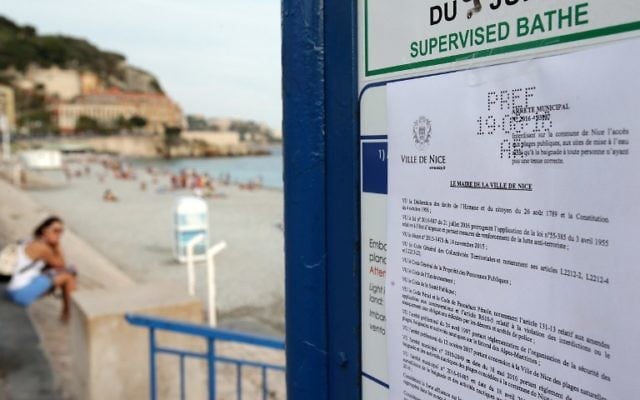 Photo d'un arrêté interdisant aux femmes de porter un burkini sur la plage, le 19 août 2016 à Nice, dans le sud de France (Crédit : AFP PHOTO / JEAN CHRISTOPHE MAGNENET)