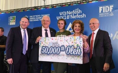 Rebecca Glanzer (eu centre), 22 ans, est la 50 000e personne à faire son alyah via l'association Nefesh B’Nefesh. Elle est entourée, de gauche à droite, du rabbin Yehoshua Fass, fondateur et directeur exécutif de l'organisation, du président Reuven Rivlin, de la ministre de l'Immigration et de l'Intégration Sofa Landver, et de Tony Gelbart, fondateur de Nefesh B'Nefesh, à l'aéroport Ben Gurion, le 17 août 2016. (Crédit : Shahar Azran) Rebecca Glanzer (eu centre), 22 ans, est la 50 000e personne à faire son alyah via l'association Nefesh B’Nefesh. Elle est entourée, de gauche à droite, du rabbin Yehoshua Fass, fondateur et directeur exécutif de l'organisation, du président Reuven Rivlin, de la ministre de l'Immigration et de l'Intégration Sofa Landver, et de Tony Gelbart, fondateur de Nefesh B'Nefesh, à l'aéroport Ben Gurion, le 17 août 2016. (Crédit : Shahar Azran)