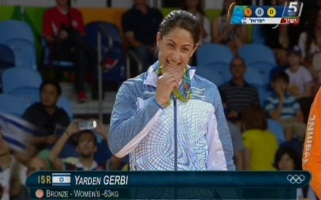 La judokate israélienne Yarden Gerbi mord sa médaille de bronze, obtenue dans le tournoi de judo féminin des -63kg aux Jeux olympiques de Rio, le 9 août 2016. (Crédit : capture d’écran Chaîne 55) La judokate israélienne Yarden Gerbi mord sa médaille de bronze, obtenue dans le tournoi de judo féminin des -63kg aux Jeux olympiques de Rio, le 9 août 2016. (Crédit : capture d’écran Chaîne 55)