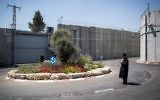 Un juif ultra-orthodoxe près du carrefour devant l'entrée du Tombeau de Rachel, entouré de la barrière de séparation, à Bethléem, le 26 juin 2014. (Crédit : Hadas Parush/Flash90)