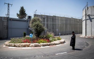 Un juif ultra-orthodoxe près du carrefour devant l'entrée du Tombeau de Rachel, entouré de la barrière de séparation, à Bethléem, le 26 juin 2014. (Crédit : Hadas Parush/Flash90)