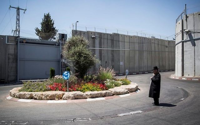 Un juif ultra-orthodoxe près du carrefour devant l'entrée du Tombeau de Rachel, entouré de la barrière de séparation, à Bethléem, le 26 juin 2014. (Crédit : Hadas Parush/Flash90)