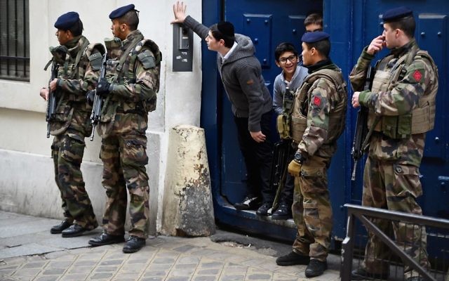 Des enfants sortent de leur école gardée par des militaires armées, dans le quartier juif du Marais, à Paris, le 13 janvier 2015. (Crédit : Jeff J. Mitchell/Getty Images)