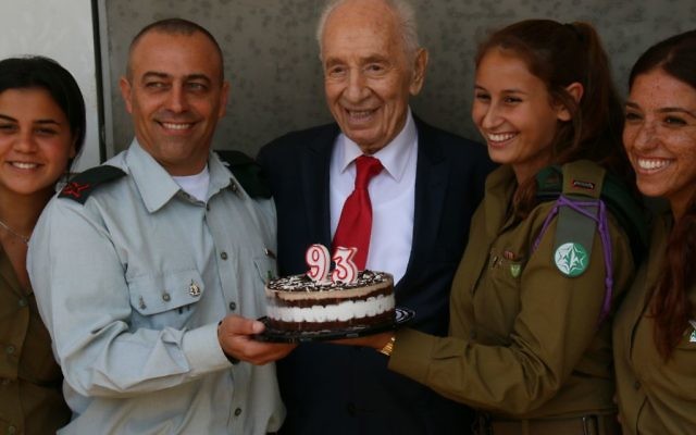 Shimon Peres (au centre),ancien président d'Israël, a fêté son 93e anniversaire entouré de Dror Shalom (à gauche), directeur de la division de recherche des renseignements militaires, et de soldats de cette division, le 2 août 2016. (Crédit : Yosef Angel)