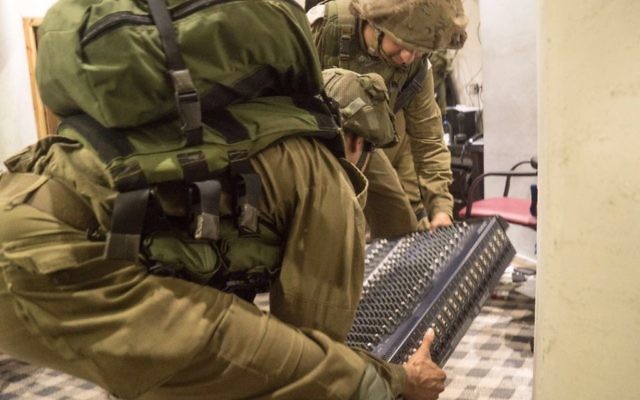 Des soldats israéliens démantèlent l'équipement de radio-transmission de la radio al-Sabanel, à Dura, près de Hébron, en Cisjordanie, le 31 août 2016. (Crédit : unité des porte-paroles de l'armée israélienne)