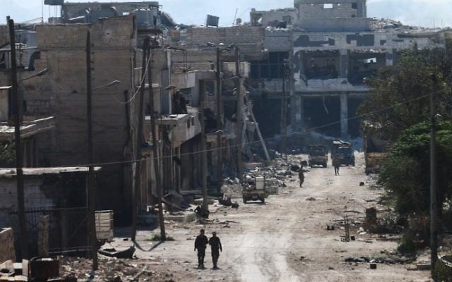 Des combattants syriens pro-régime dans les rues de Ramussa, après leur prise de contrôle d'un district stratégiquement important dans la banlieue d'Alep la veille, le 9 septembre 2016. (Crédit : AFP/George Ourfalian)