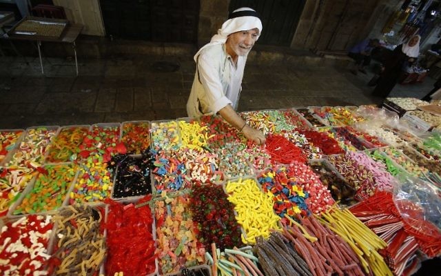 Un Palestinien achète des bonbons pendant la préparation des magasins musulmans à la fête de l'Aïd al-Adha, sur le marché de la Vieille Ville de Jérusalem, le 11 septembre 2016. (Crédit : AFP/Hazem Bader) Un Palestinien achète des bonbons pendant la préparation des magasins musulmans à la fête de l'Aïd al-Adha, sur le marché de la Vieille Ville de Jérusalem, le 11 septembre 2016. (Crédit : AFP/Hazem Bader)