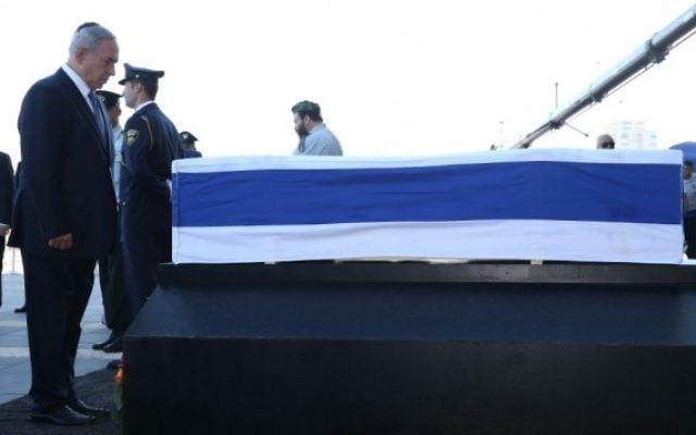 Benjamin Netanyahu se recueille sur le cercueil de Shimon Peres, le 29 septembre 2016 sur le parvis de la Knesset (Crédit :  bureau de Yizhak Harari / Knesset porte-parole)