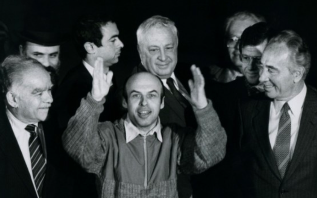 L'ancien prisonnier soviétique de Sion Natan Sharansky avec le Premier ministre Shimon Peres (d), ministre des Affaires étrangères Yitzhak Shamir (g) et Ariel Sharon (en arrière-plan), après sa sortie de prison en Union soviétique, à son arrivée en Israël le 11 février 1986. (Moshe Shai / FLASH90)