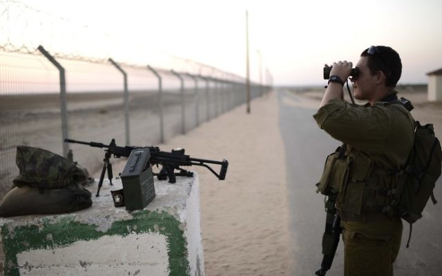 Un soldat israélien de la 10e division regarde avec des jumelles dans la bande de Gaza depuis une commune israélienne voisine, le 7 août 2014. Illustration. (Crédit : Tomer Neuberg/ Flash90)