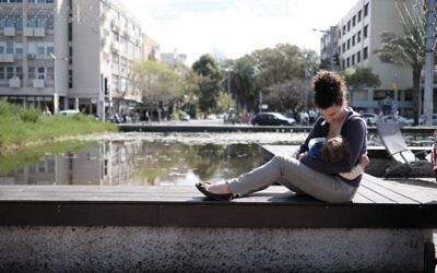Une mère allaite son enfant (Crédit : Tomer Neuberg/Flash90)