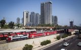 Un train longe l'autoroute Ayalon près de la gare centrale "Savidor" de Tel Aviv, le 23 août 2016. (Crédit : Miriam Alster/Flash90)