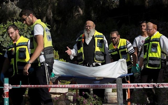 Les secouristes de Zaka transportent le corps d'un père endeuillé qui s'est suicidé sur la tombe de son fils, au cimetière militaire du mont Herzl, à Jérusalem, le 2 septembre 2016. (Crédit : Yonatan Sindel/Flash90)