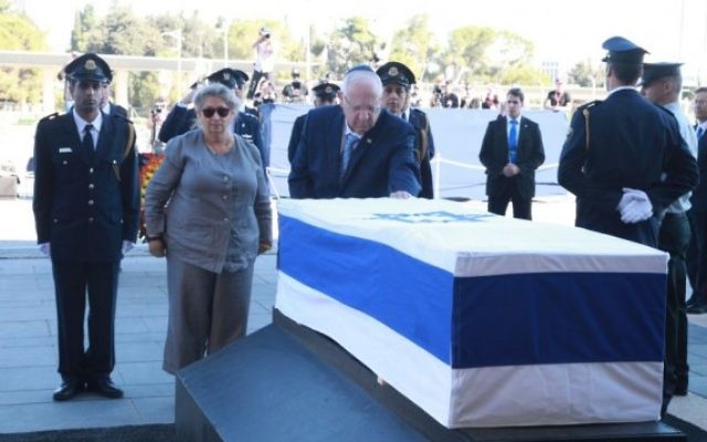 Le président Reuven Rivlin dépose une couronne sur le cercueil de l'ancien président et Premier ministre Shimon Peres dont la dépouille se trouve à la Knesset, le 29 septembre 2016. (Crédit : bureau de Yizhak Harari / Knesset porte-parole)