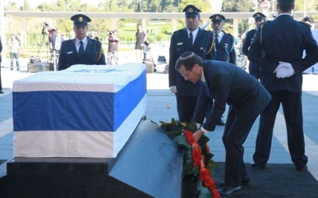 Isaac Herzog se recueille sur le cercueil de Shimon Peres, le 29 septembre 2016 sur le parvis de la Knesset (Crédit :  bureau de Yizhak Harari / Knesset porte-parole)