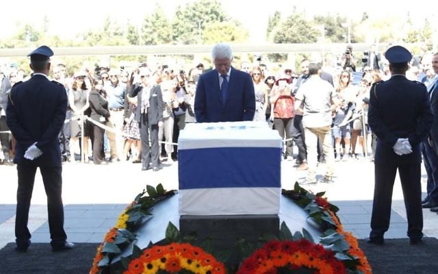 Bill Clinton se recueille sur le cercueil de Shimon Peres, le 29 septembre 2016 sur le parvis de la Knesset (Crédit :  bureau de Yizhak Harari / Knesset porte-parole)