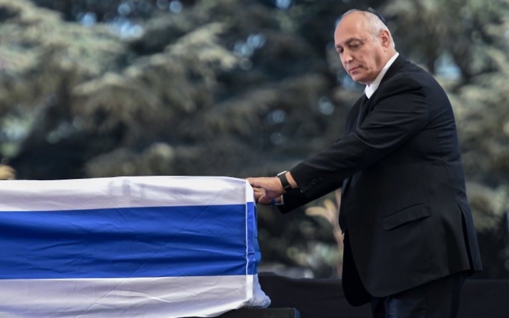 Chemi Peres devant le cercueil de son père, l'ancien président Shimon Peres, au cimetière national du mont Herzl, à Jérusalem, le 30 septembre 2016. (Crédit : AFP/Nicholas Kamm) Chemi Peres devant le cercueil de son père, l'ancien président Shimon Peres, au cimetière national du mont Herzl, à Jérusalem, le 30 septembre 2016. (Crédit : AFP/Nicholas Kamm)