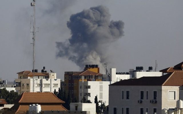 La fumée monte depuis l'est de Gaza Ville après une frappe militaire israélienne sur une position du Hamas, en représailles après un tir de roquette, le 5 octobre 2016. (Crédit : AFP/Mahmud Hams)
