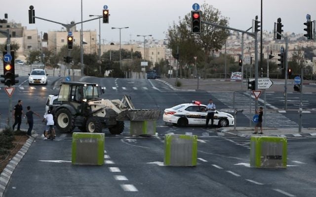 Des blocs de béton sont installés par les forces israéliennes sur une route reliant le quartier arabe de Jérusalem Est de Beit Hanina à Jérusalem Ouest, avant Yom Kippour, le 11 octobre 2016. (Crédit : AFP/Ahmad Gharabli)