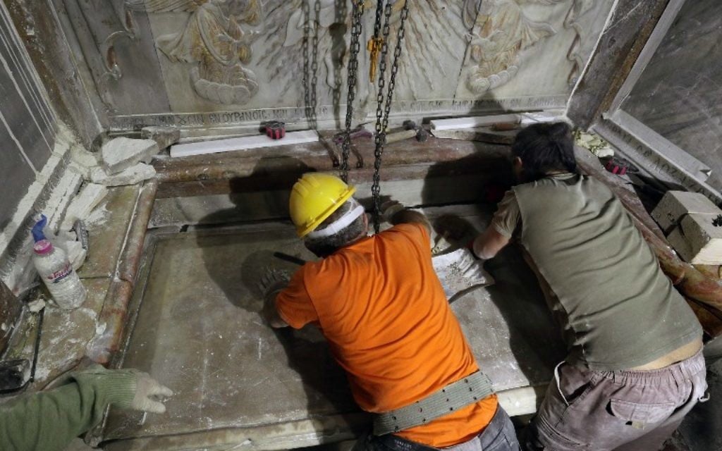 Des experts en restauration replace la plaque de marbre qui couvrait le Tombeau de Jésus, où son corps aurait été enterré, après son ouverture pendant trois jours pour permettre sa restauration et son étude, à Jérusalem, le 28 octobre 2016. (Crédit : AFP/Gali Tibbon)