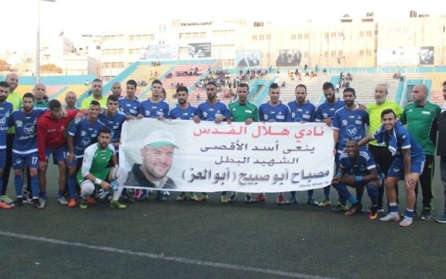 L'équipe de foot palestinienne Hilal al-Quds pose avec une bannière à la gloire du terroriste palestinien Mesbah Abu Sabih, qui a tué deux Israéliens dans une fusillade à Jérusalem le 9 octobre 2016. (Facebook) L'équipe de foot palestinienne Hilal al-Quds pose avec une bannière à la gloire du terroriste palestinien Mesbah Abu Sabih, qui a tué deux Israéliens dans une fusillade à Jérusalem le 9 octobre 2016. (Facebook)