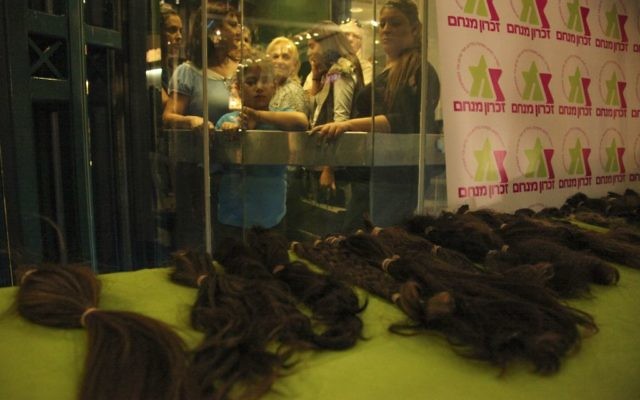 Dons de cheveux pour des perruques destinées à des enfants souffrant d'un cancer pendant un évènement organisé par Zichron Menachem, l'association israélienne pour le soutien des enfants atteints de cancer et de leurs familles. Illustration. (Crédit : Meital Cohen/Flash90)