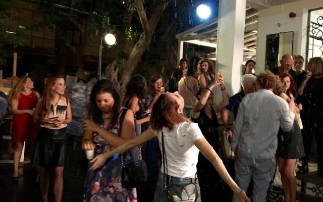 Une jeune femme sous la neige artificielle à l'inauguration du café Table Talk de Tel Aviv. (Crédit : Anna Rudnitsky/Times of Israel)