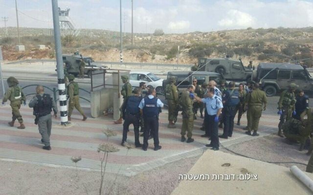 Les forces de l'ordre israéliennes sur les lieux d'une attaque au couteau au carrefour Tapuah, près de Naplouse, en Cisjordanie, le 19 octobre 2016. (Crédit : police israélienne)
