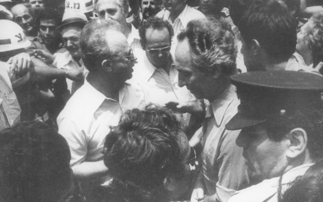 Shimon Peres, alors ministre de la Défense, et l'ancien Premier ministre Yitzhak Rabin, rencontrent les otages libérés d'Entebbe à leur atterrissage en Israël, le 4 juillet 1976. (Crédit : archives du ministère de la Défense) Shimon Peres, alors ministre de la Défense, et l'ancien Premier ministre Yitzhak Rabin, rencontrent les otages libérés d'Entebbe à leur atterrissage en Israël, le 4 juillet 1976. (Crédit : archives du ministère de la Défense)
