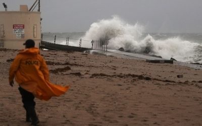 Un policier parcourt la plage tandis que les vagues s'écrasent sur la plage, avec l'arrivée de l'ouragan Matthew, à Singer Island, en Floride, le 6 octobre 2016. (Crédit : Joe Raedle/Getty Images/AFP)