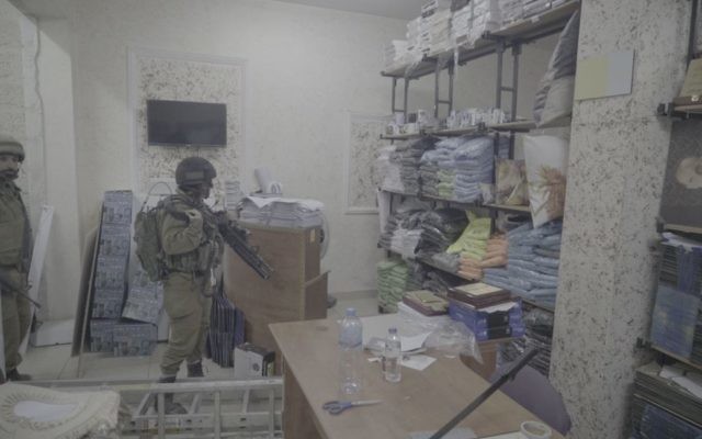 Des soldats dans une imprimerie qui produisait, d'après l'armée israélienne, des affiches et d'autres documents de soutien au terrorisme, à A-Ram, en Cisjordanie, le 19 octobre 2016. (Crédit : unité des porte-paroles de l'armée israélienne)