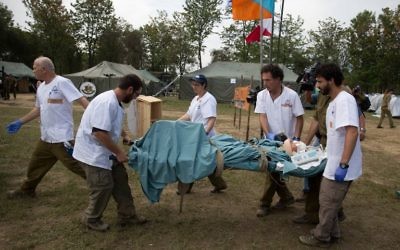 Une unité militaire médicale israélienne transporte le corps de Krishna Khadka, retrouvée vivante dans les ruines d'un immeuble effondré à Katmandou, le 1er mai 2015. Elle va être examinée par une équipe médicale dans un hôpital de campagne mis en place par l'armée israélienne. (Crédit : Menahem Kahana)
