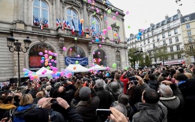 Les gens lancent des ballons devant la mairie du 11ème arrondissement de Paris, le 13 novembre 2016, pour marquer le premier anniversaire des attentats de Paris. (Crédit : AFP/ ALAIN JOCARD)