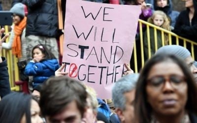 Illustration : Des manifestants protestent contre le racisme et la haine, après la découverte de croix gammées au parc Adam Yauch de Brooklyn, à New York, le 20 novembre 2016. (Crédit : AFP/Angela Weiss)