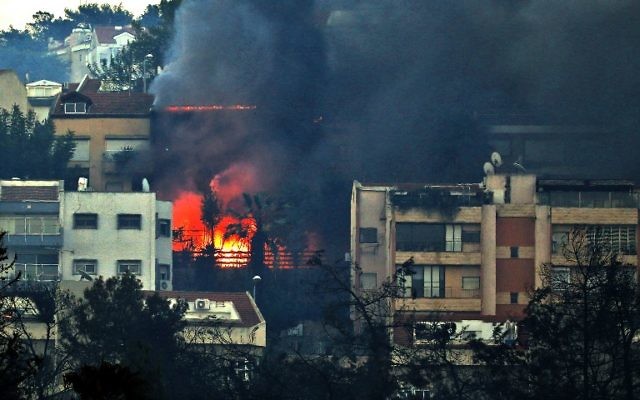 De la fumée et des flammes d'un immeuble à Haifa, le 24 novembre 2016 (Crédit : AFP / AHMAD GHARABLI) De la fumée et des flammes d'un immeuble à Haifa, le 24 novembre 2016 (Crédit : AFP / AHMAD GHARABLI)
