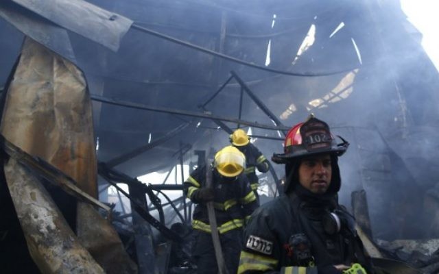 Des pompiers israéliens aident à éteindre un incendie dans la ville du nord de Haïfa le 24 novembre 2016. (Crédit : AFP/Jack Guez)
