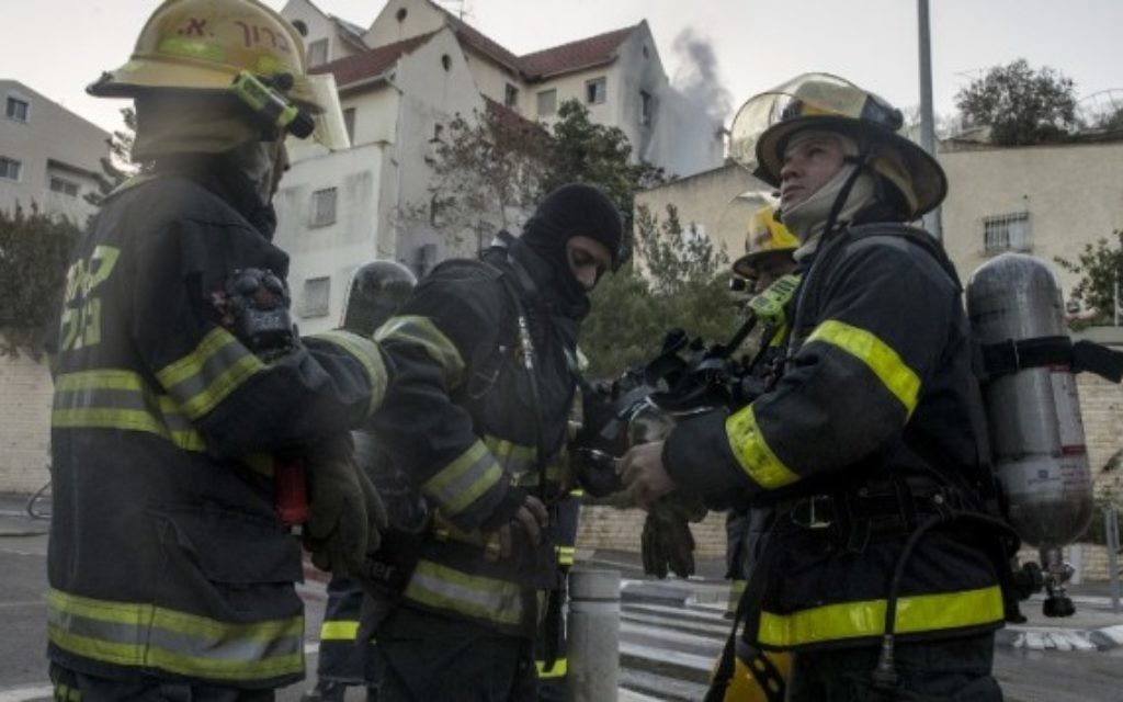 Des pompiers palestiniens aident à éteindre un incendie dans la ville du nord de Haïfa le 24 novembre 2016. (Jack Guez / AFP)