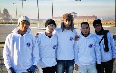(De gauche à droite) Simeon Lhouvum, Yaniv Hinge, David Haokip, Etzion Bait et Obed Lhouvum de la communauté Bnei Menashe devant le camp de concentration d'Auschwitz II en Pologne, le 28 novembre 2016 (Crédit : Autorisation Shavei Israel)