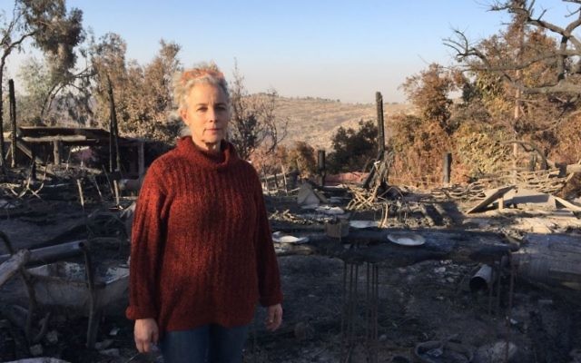 Rama Ben Zvi devant les restes carbonisés de son restaurant campagnard célèbre, le Rama's Kitchen, dans le village de Nataf, le 27 septembre 2016. (Crédit : Jessica Steinberg/Times of Israel)