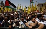 Les étudiants palestiniens qui soutiennent le mouvement du Fatah agitent le drapeau national et celui du mouvement durant un rassemblement en vue d'une campagne électorale pour le conseil étudiant à la  Birzeit University, à proximité de la ville cisjordanienne de Ramallah le 26 avril 2016 (Crédit :  / AFP PHOTO / ABBAS MOMANI