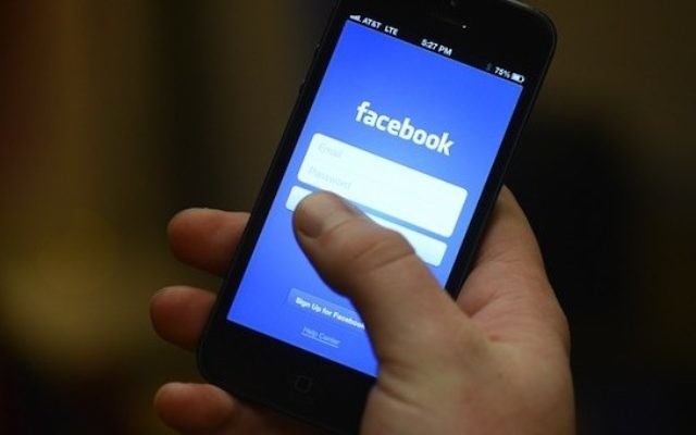 Une photo d'illustration d'un individu utilisant une application mobile Facebook (Crédit : CC BY melenita2012/Flickr)