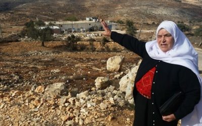 Mariam Hammad, une femme palestinienne de Silouad, proche d'Amona, désigne une parcelle de terre qui appartenait selon elle à sa famille, mais qui a été saisie par les Israéliens pour construire l'avant-poste d'Amona, en Cisjordanie, en  novembre 2016.  (Crédit : Raphael Ahren/Times of Israel)