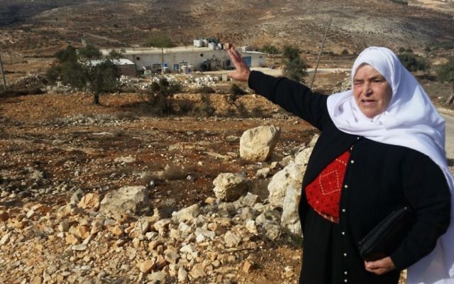 Mariam Hammad, une femme palestinienne de Silouad, proche d'Amona, désigne une parcelle de terre qui appartenait selon elle à sa famille, mais qui a été saisie par les Israéliens pour construire l'avant-poste d'Amona, en Cisjordanie, en  novembre 2016.  (Crédit : Raphael Ahren/Times of Israel)