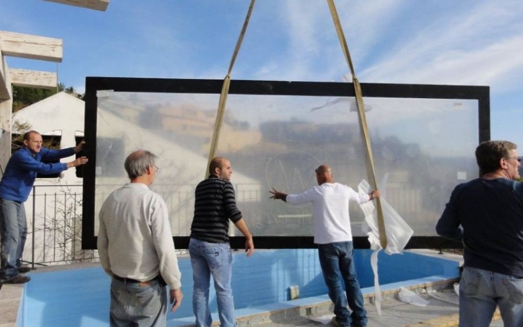 Installation de la paroi principale de l'aquarium. (Crédit : Facebook/Eli's 10,000 Gallon Reef Aquarium)