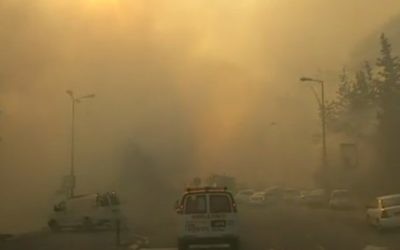 Une ambulance se frayant son chemin à travers les rues enfumées de Haïfa, le 24 novembre 2016. (Crédit : capture d'écran Dixième chaîne)