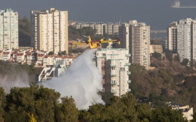 Un avion bombardier d'eau aide à éteindre les flammes qui ravagent Haïfa, le 25 novembre 2016. (Crédit : AFP/Menahem Kahana) Un avion bombardier d'eau aide à éteindre les flammes qui ravagent Haïfa, le 25 novembre 2016. (Crédit : AFP/Menahem Kahana)