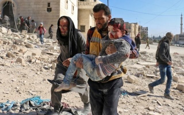 Un bénévole, membre des Casques blancs, transporte un enfant sauvé des décombres après un bombardement de la ville d'Alep, le 24 novembre 2016. (Crédit : Ameer Alhalbi/AFP) Un bénévole, membre des Casques blancs, transporte un enfant sauvé des décombres après un bombardement de la ville d'Alep, le 24 novembre 2016. (Crédit : Ameer Alhalbi/AFP)