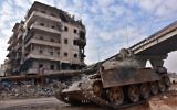 Les troupes du gouvernement syrien en patrouille dans le quartier al-Sakhour, à l'est d'Alep, qui vient d'être repris aux rebelles, le 7 décembre 2016. (Crédit : George Ourfalian/AFP)