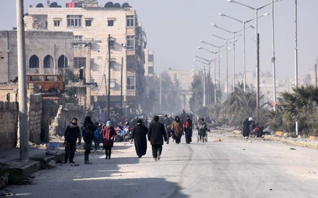 Les civils syriens marchant vers un poste de contrôle tenu par les forces pro-gouvernementales, au rond-point de la rue Al-Hawoz, après avoir quitté les quartiers de l'est d'Alep le 10 décembre 2016 (Crédit : George Ourfalian/AFP)
